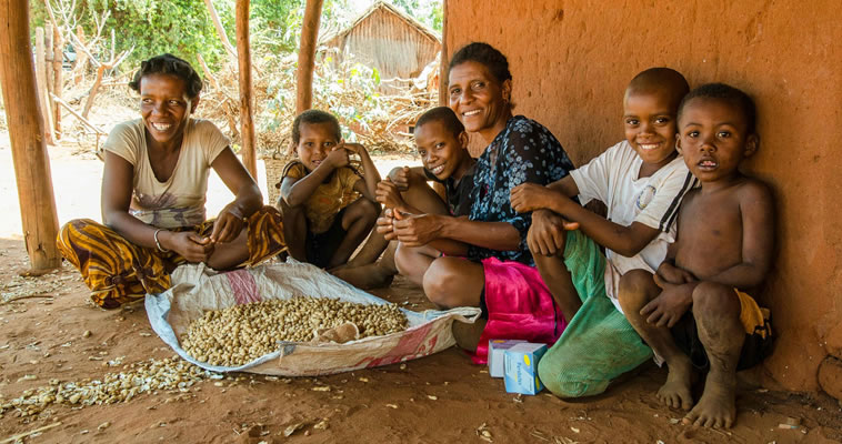 Motehrs sit and smile with their children