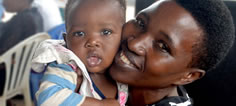 A mother holds her smiling infant