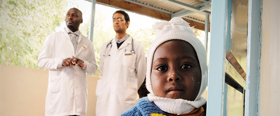 Photo of a child in a hospital with two pediatricians