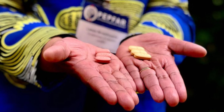 Hands holding a set of two different pills.