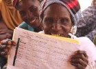 A member of the Albarka women’s group in Iguéfane village holds up a ledger of fruit and vegetable sales from the oasis garden.