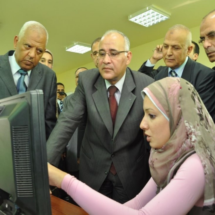 Woman at computer with people viewing her screen