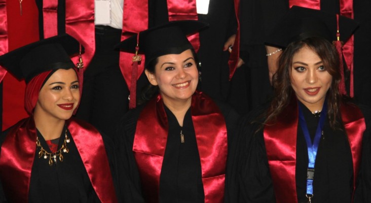 Graduates smile during graduation ceremony.