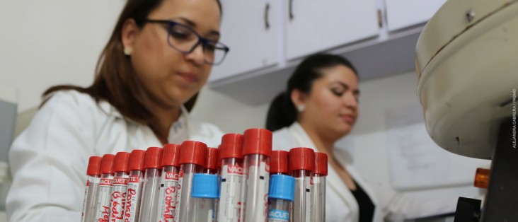 A female lab technician monitors a centrifuge