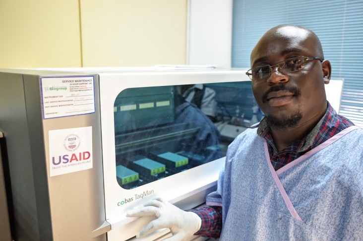 A lab technician stands in front of a HIV testing machine in Copperbelt Province.