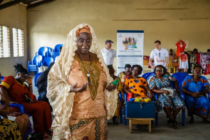 Woman wearing a veil is talking to a crowd of woman