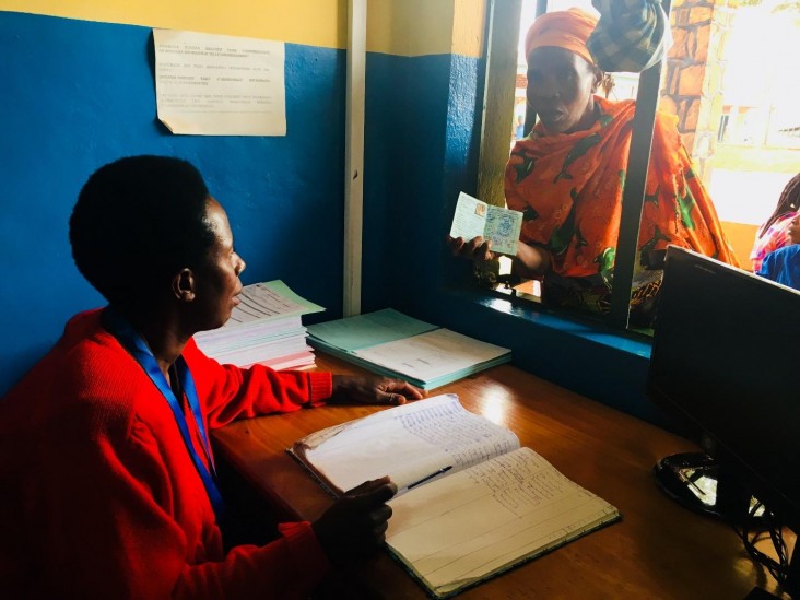 A client presents her CBHI card to the Remera-Rukoma Hospital receptionist.