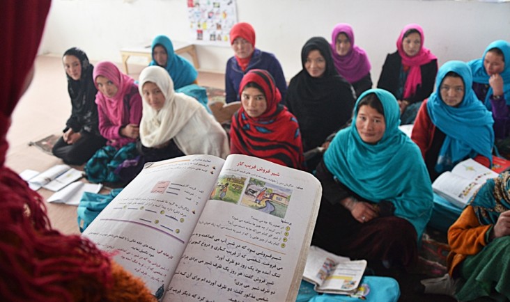 A group of students listen attentively and taking notes in class.