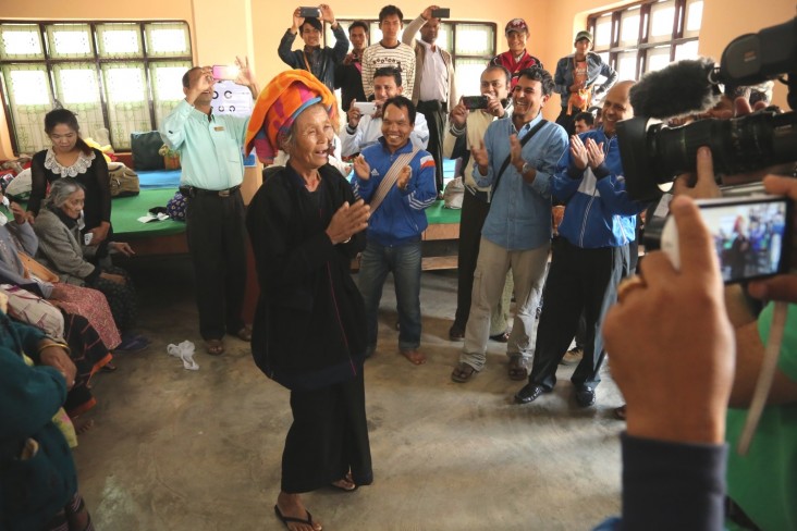 A woman dances after removing her bandages following cataract surgery.