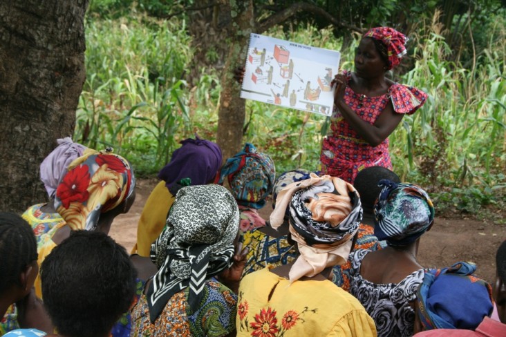 A woman shows and educational guide to other women at a training