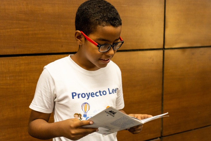 Child reads and focuses on USAID READ Project's book.