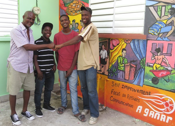 John Riviere greets Job James, 24, far right, as Donny Delice, 18, second from left, and Omar Darwton, 17, look on.