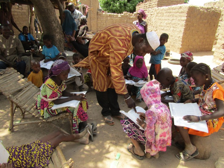 Moussa Konaré tutors his and other children outside his home