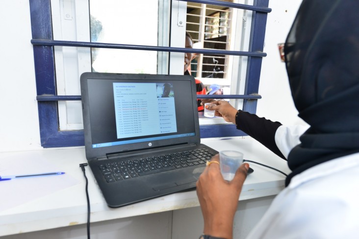 A medical officer at the medically assisted therapy clinic supported by USAID in Mombasa hands methadone to a patient.