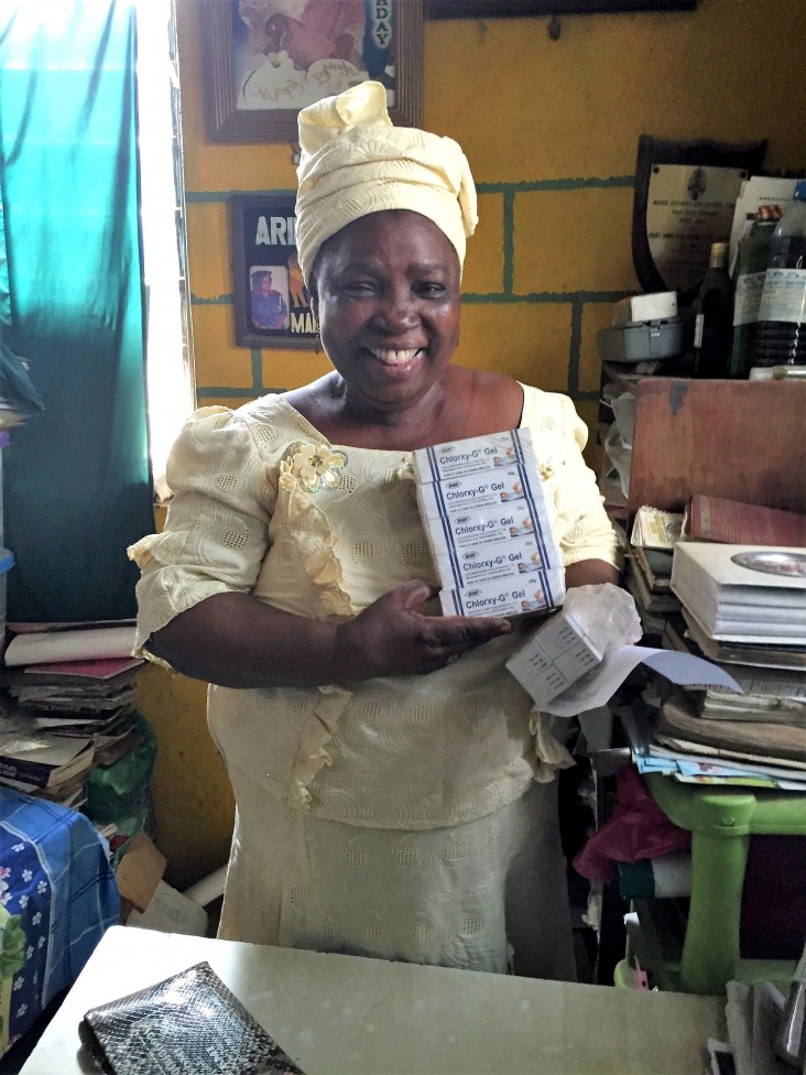 A woman holds boxes of chlorhexidine gel.