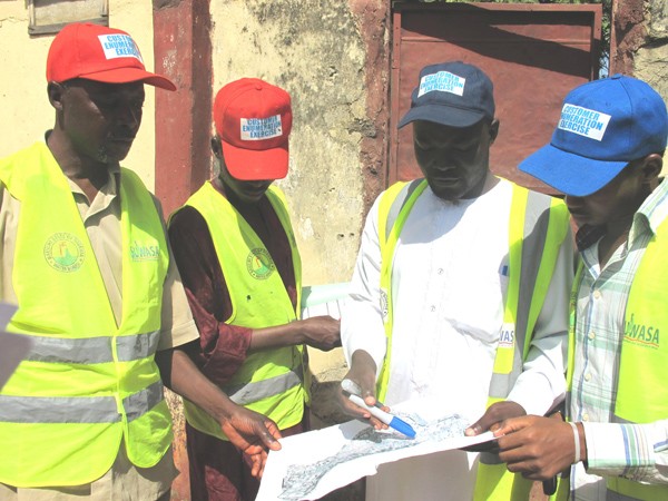 Surveyors review a map showing households selected to take part in the survey.