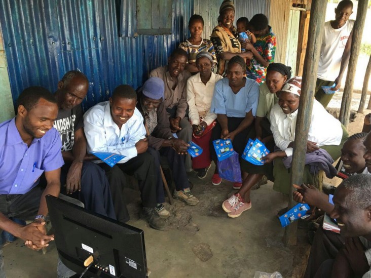 Customers gather around one of Orb’s solar-powered televisions.