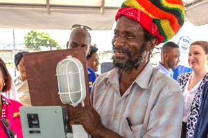 A resident of Majesty Gardens holds up a readyboard, encouraging the community to continue to adopt the new technology. 