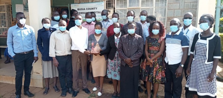 Clinical officers, nurses, lab technologists, pharmacists, HIV testing counselors, peer educators and mentor mothers from the Busia County Referral Hospital Comprehensive Care Center pose with their PEPFAR Heroes Award. 