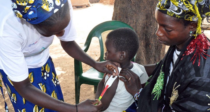 Photo of a child being measured by a community health worker