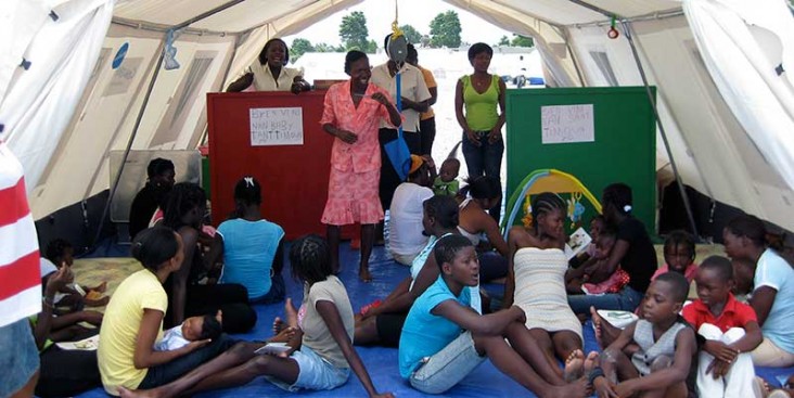 A health worker talks to a group of people about nutrition