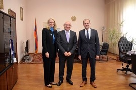 people pose for a standing photo during an official meeting