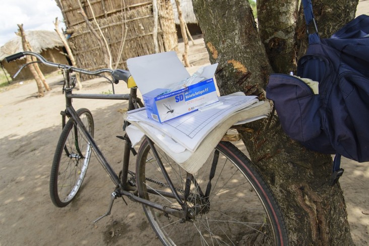 José Azevedo's bicycle is standing against a tree, with a local straw hut in the back suggesting one of Azevedo's health visits.