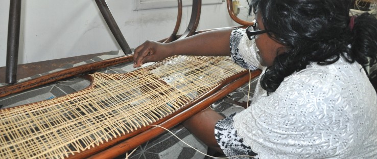 Claudette Thompson demonstrates her skills by caning one of many chairs for her organization Superior Crafts and More Ltd.