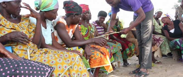 Lead farmer John Mulnye explains the row spacing planting method to smallholder women farmers.