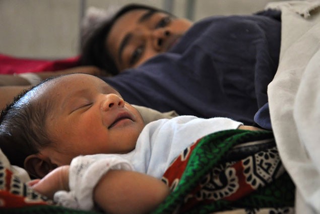 Newborn baby sleeps peacefully next to its mother