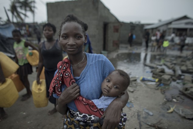 “In all my life I have never seen such a storm like this.” Enia Joao, 24, has 3 children, the youngest  one being 10months old on back.