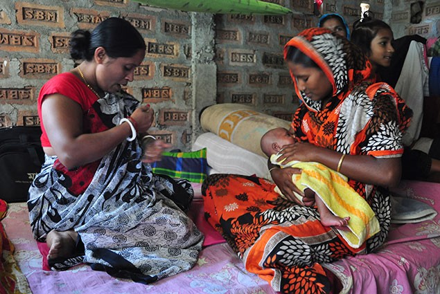 A healthworker does the 28-day check up and counsels the mother on proper breastfeeding practices.