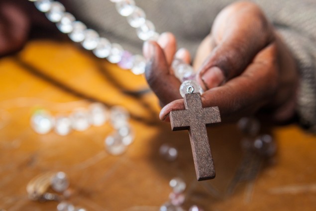 A woman holds a beaded necklace