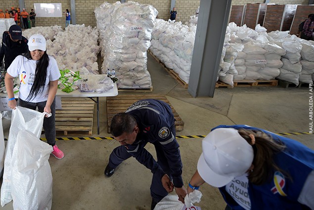 Volunteers and firefighters arrange bags with US humanitarian aid goods in Cucuta, Colombia, on the border with Tachira, Venezuela.