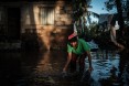 Lidia Mubando, 66, tries to recover a metal sheet for roof which was blown away by the cyclone Idai from water in Buzi, Mozambique, on March 22, 2019.