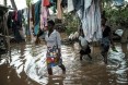 Albertina Francisco (L), and her daughters Rosita Moises Zacarias (R), 15, and Joaninha Manuel, 9, walk in flooded waters from their house destroyed by the cyclone Idai as they go to seep in a shelter in Buzi, Mozambique, on March 22, 2019.