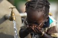 Image of girl in Ethiopia drinking from water tank