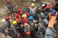 Members of a USAID DART help pull 15-year-old Pemba Tamang from rubble five days after a M7.8 earthquake in Nepal.