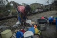 Mariamo Humberto, washes dishes at her family’s home that had all but been destroyed. “When the storm started we began running to find a safe place. We had no food and our clothes were soaked We couldn’t believe to be alive. We were very scared when the storm started. And now we are here. We have lost clothes and even food. Everything is wet including clothes.” Photo by  Josh Estey/CARE