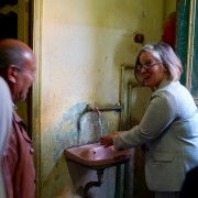 Woman pours a glass of water from faucet