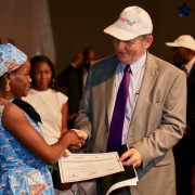 Ambassador Dennis B. Hankins providing certificate to a beneficiary