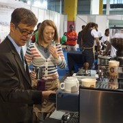 U.S. Chargé d'affaires to Ethiopia Peter Vrooman tries his hand as a barista at the 7th Africa Barista Championship & All Star Challenge booth. The booth is sponsored by USAID’s East Africa Trade and Investment Hub.