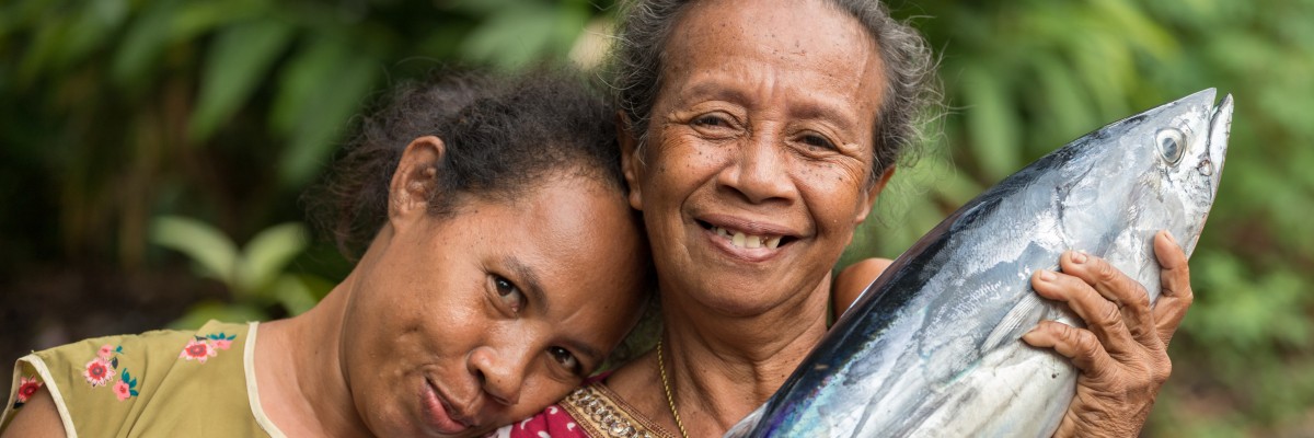 Cheerful women proudly display a fresh skipjack tuna in Banda Neira, Maluku islands.