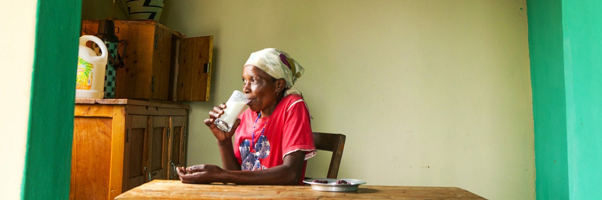 Bedabazingwa drinks fresh milk from her dairy cow, which she acquired through her coffee cooperative’s fund. Credit: Andrew Esiebo, courtesy of USADF